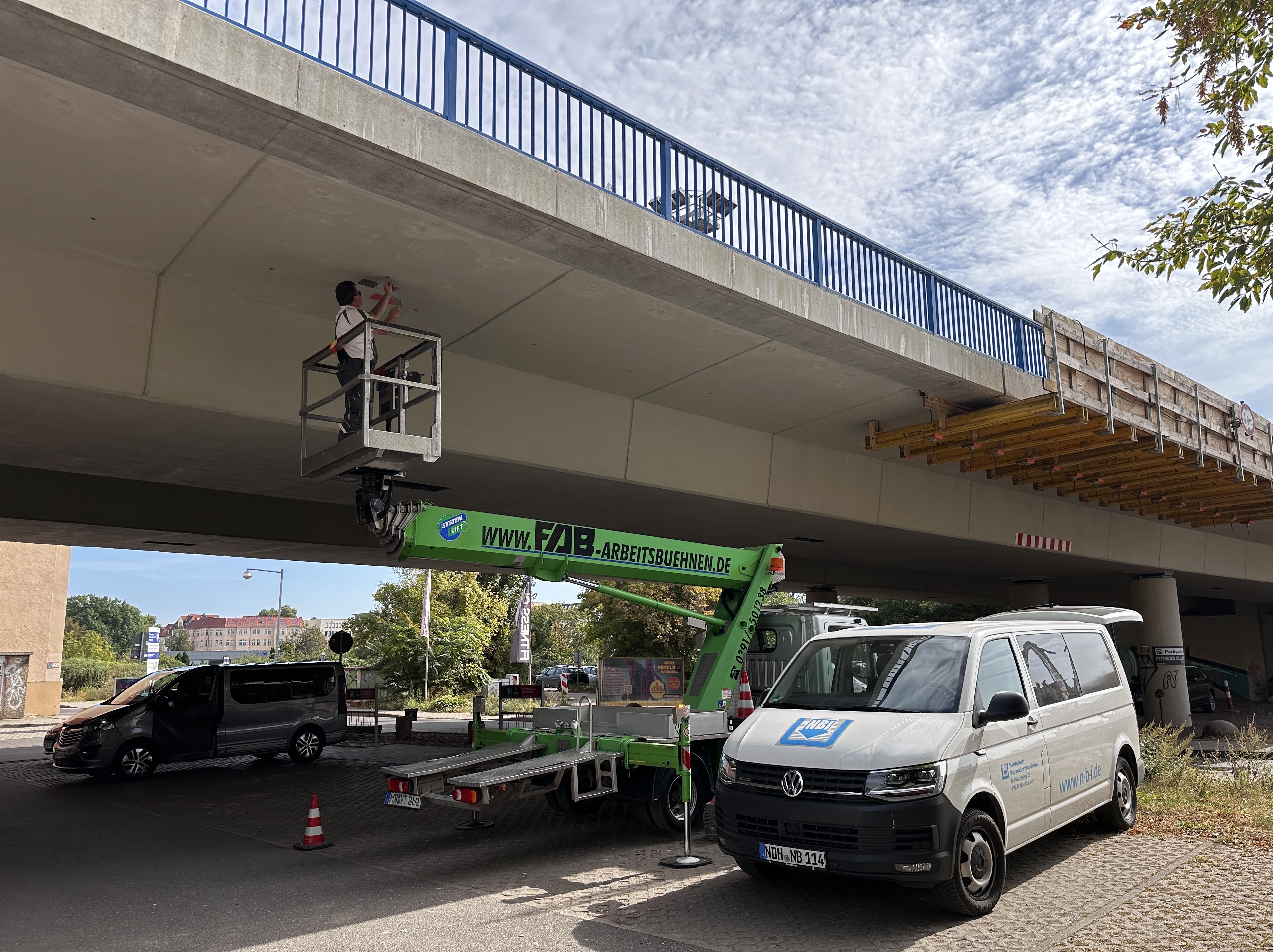 Ein Mitarbeiter führt eine zerstörungsfreie Prüfung der Betondruckfestigkeit und Lokalisierung der Bewehrungslage an einem Brückenkragarm durch.