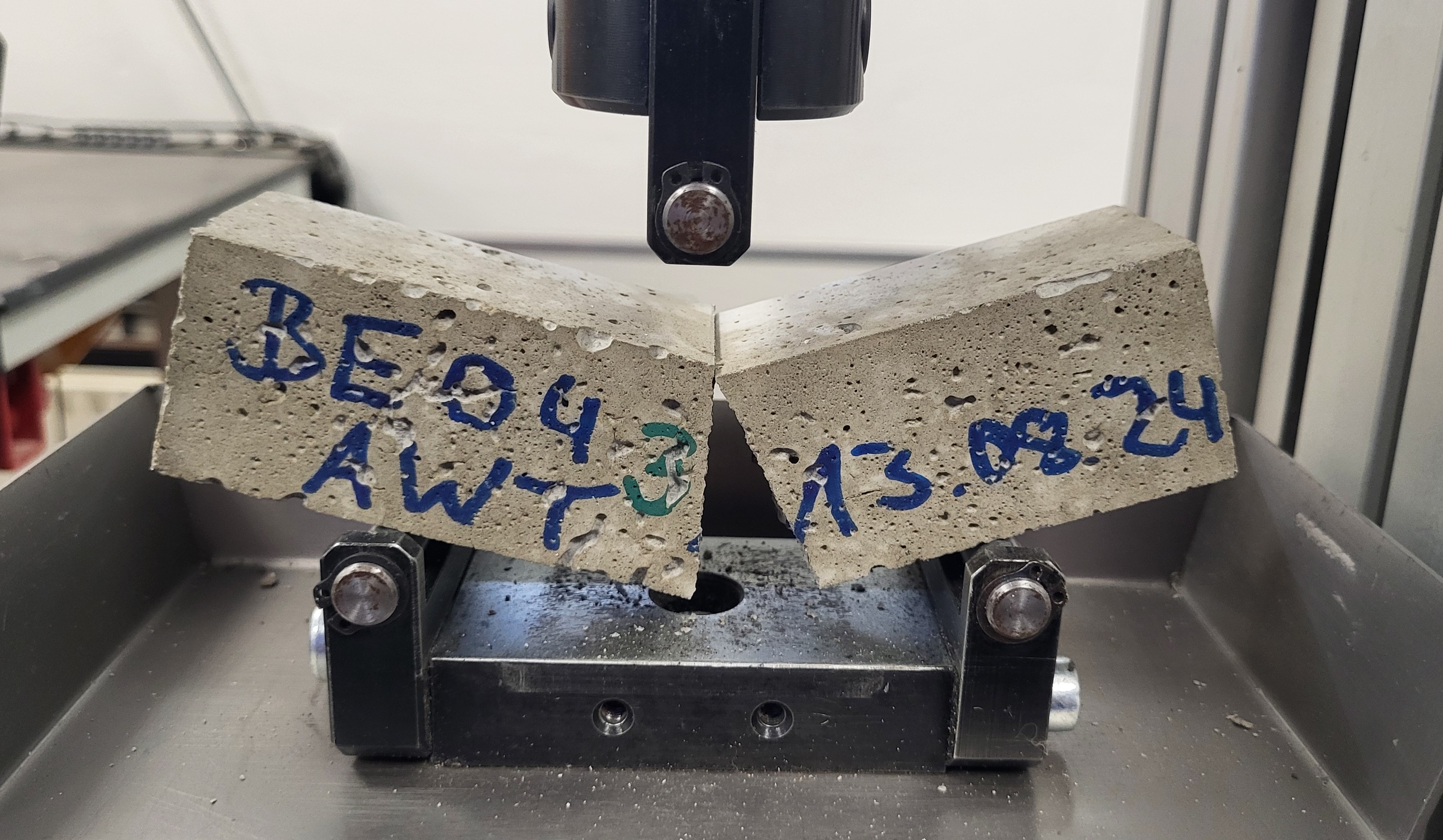 Ein beschriftetes Mörtelprisma wurde in einer spezialisierten Prüfanlage auf seine Eigenschaften hin zerstörend geprüft.