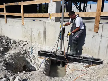 Das Bohrgerät nimmt eine Probe für erweiterte Bauwerksuntersuchungen an einem Schornstein. 