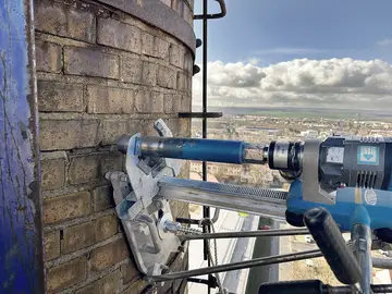 Das Bohrgerät nimmt eine Probe für erweiterte Bauwerksuntersuchungen an einem Schornstein. 