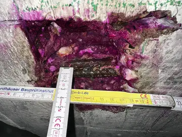 Eine frische Stemmstelle im Beton wurde mit Phenolphthalein besprüht, um die Karbonatisierungstiefe zu bestimmen und zu messen.